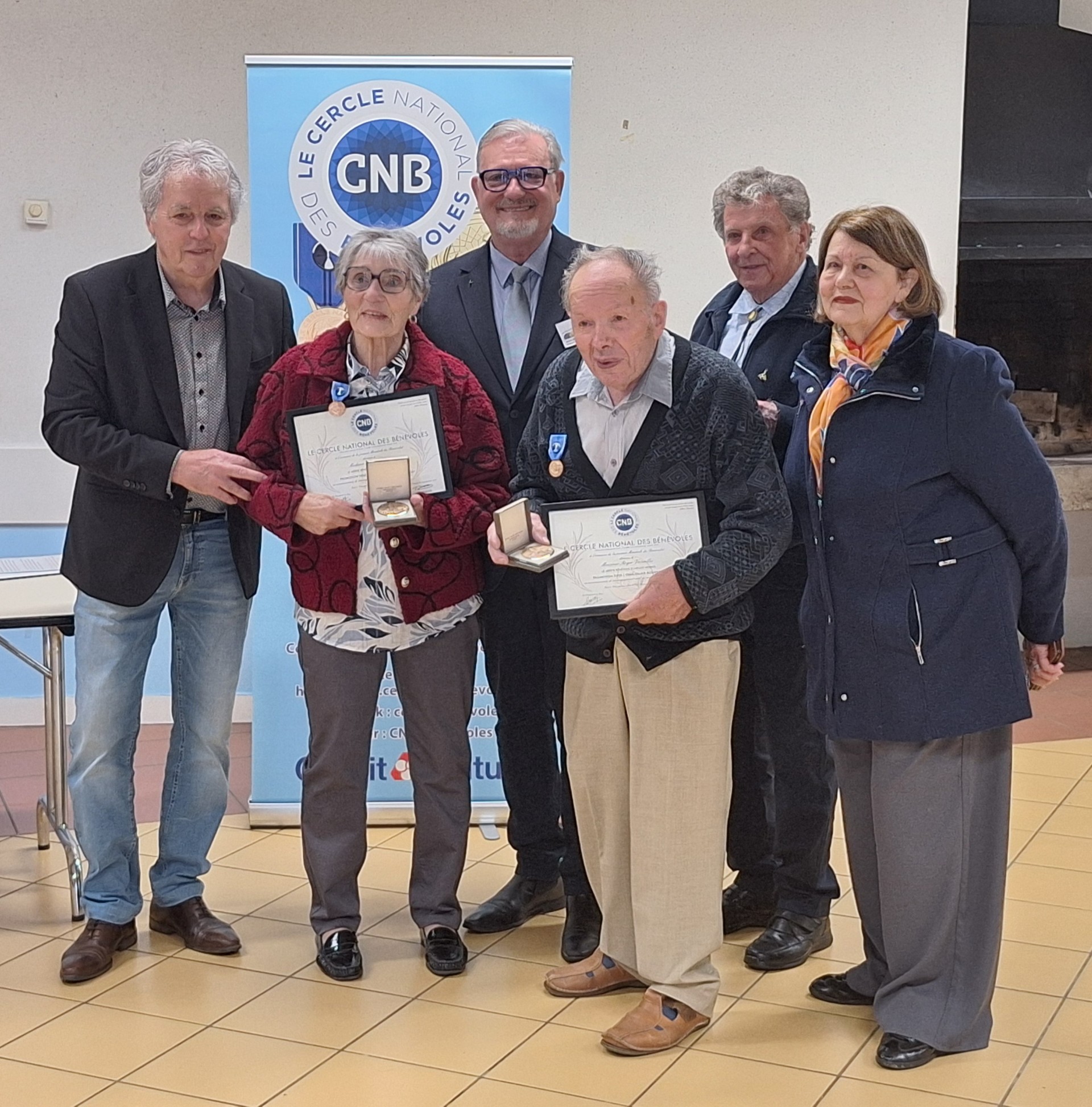 Le Cercle National des Bénévoles et la municipalité de Gan (64) se sont réunis 16 mai 2026 pour honorer deux figures incontournables de la vie associative locale. Devant un public chaleureux composé de famille, d’amis du monde associatif et d'élus, la commune de Gan a souhaité mettre en lumière un dévouement exceptionnel. Monsieur Christian Gillet, adjoint au maire, représentait la municipalité pour saluer l'engagement sans faille de ces deux Gantois. Marcelle Saba et Roger Versailles incarnent à eux deux un demi-siècle de bénévolat. Depuis 1975, ils sont les visages rassurants et familiers des collectes de sang organisées sur la commune. Cette fidélité associative a été doublement récompensée au cours de la matinée. Dans un premier temps, Jean-Michel Darteyron, délégué régional Aquitaine du Cercle National des Bénévoles, est venu leur remettre officiellement, au nom du président national Jean-Jacques Brient, le Diplôme d’honneur du Mérite Bénévole, échelon exceptionnel de Vermeil. À cette reconnaissance s'est ajoutée celle de leur propre commun. Christian Gillet, au nom de Francis PEES, maire de Gan leur a remis la médaille d'honneur de la ville sous les applaudissements nourris de l'assemblée. Félicitations à nos deux récipiendaires. Jean Michel DARTEYRON Le Cercle National des Bénévoles et la municipalité de Gan (64) se sont réunis 16 mai 2026 pour honorer deux figures incontournables de la vie associative locale. Devant un public chaleureux composé de famille, d’amis du monde associatif et d'élus, la commune de Gan a souhaité mettre en lumière un dévouement exceptionnel. Monsieur Christian Gillet, adjoint au maire, représentait la municipalité pour saluer l'engagement sans faille de ces deux Gantois. Marcelle Saba et Roger Versailles incarnent à eux deux un demi-siècle de bénévolat. Depuis 1975, ils sont les visages rassurants et familiers des collectes de sang organisées sur la commune. Cette fidélité associative a été doublement récompensée au cours de la matinée. Dans un premier temps, Jean-Michel Darteyron, délégué régional Aquitaine du Cercle National des Bénévoles, est venu leur remettre officiellement, au nom du président national Jean-Jacques Brient, le Diplôme d’honneur du Mérite Bénévole, échelon exceptionnel de Vermeil. À cette reconnaissance s'est ajoutée celle de leur propre commun. Christian Gillet, au nom de Francis PEES, maire de Gan leur a remis la médaille d'honneur de la ville sous les applaudissements nourris de l'assemblée. Félicitations à nos deux récipiendaires. Jean Michel DARTEYRON